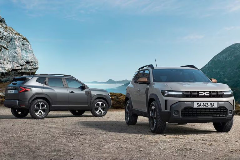 Dacia Duster leasen - twee uitvoeringen naast elkaar bij een bergachtige kust