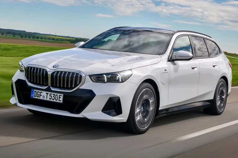 BMW 5-Serie Touring leasen - schuin vooraanzicht tijdens het rijden door een veld