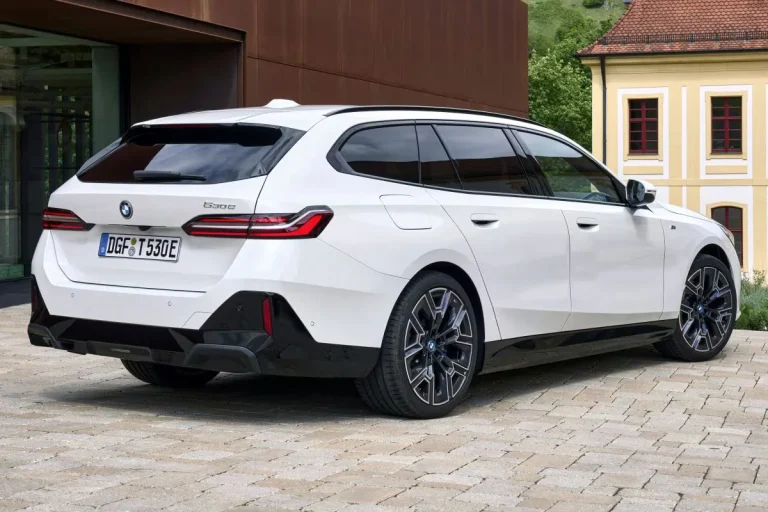 BMW 5-Serie Touring leasen - schuin achteraanzicht bij een gebouw met houten gevel