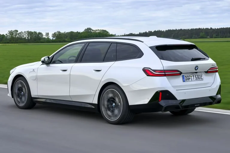 BMW 5-Serie Touring leasen - schuin achteraanzicht op de weg met een groen veld op de achtergrond