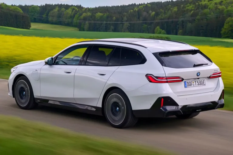 BMW 5-Serie Touring leasen - schuin achteraanzicht tijdens het rijden door een veld
