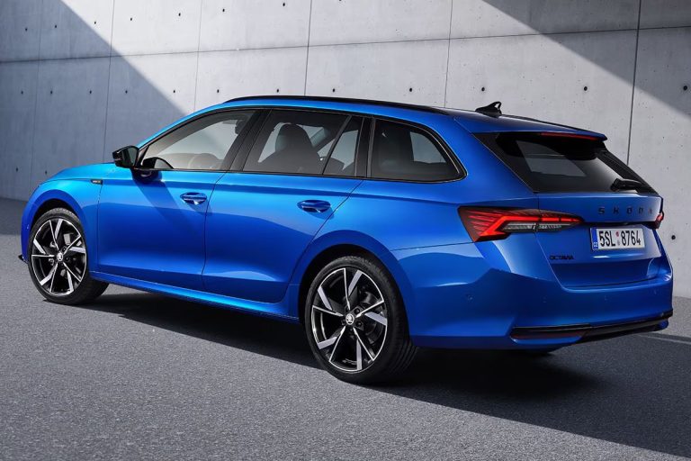Skoda Octavia Combi leasen - schuin achteraanzicht van de blauwe uitvoering bij een betonnen gebouw