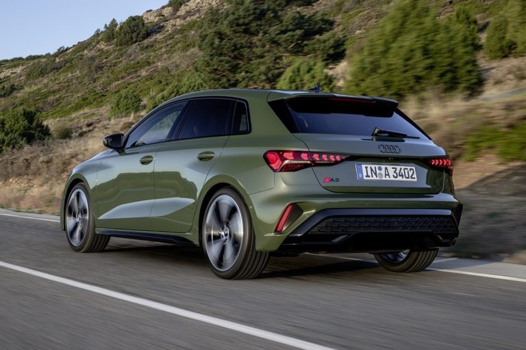 Audi A3 sportback 2024 - schuin achteraanzicht van de olijfgroene hatchback op een kustweg