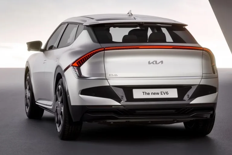 Kia EV6 leasen - schuin achteraanzicht met The New EV6-kenteken op donkere achtergrond