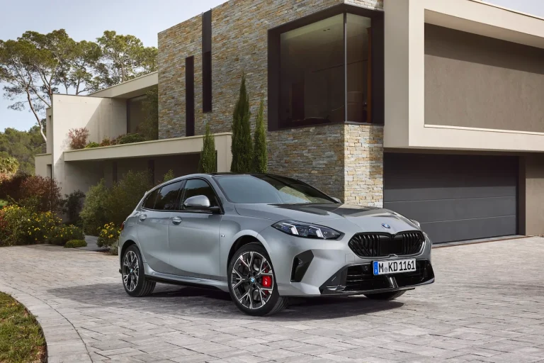 BMW 1-Serie leasen - schuin vooraanzicht van de zilvergrijze uitvoering bij een moderne villa