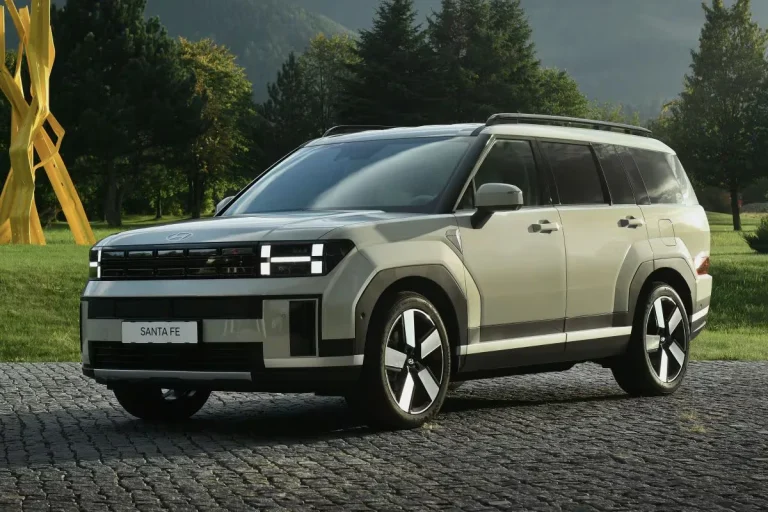 Hyundai Santa Fe leasen - schuin vooraanzicht van de crèmekleurige uitvoering in een park