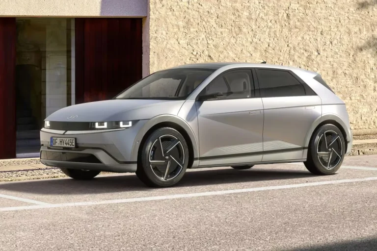 Hyundai IONIQ 5 leasen - schuin vooraanzicht bij een modern gebouw met bakstenen gevel