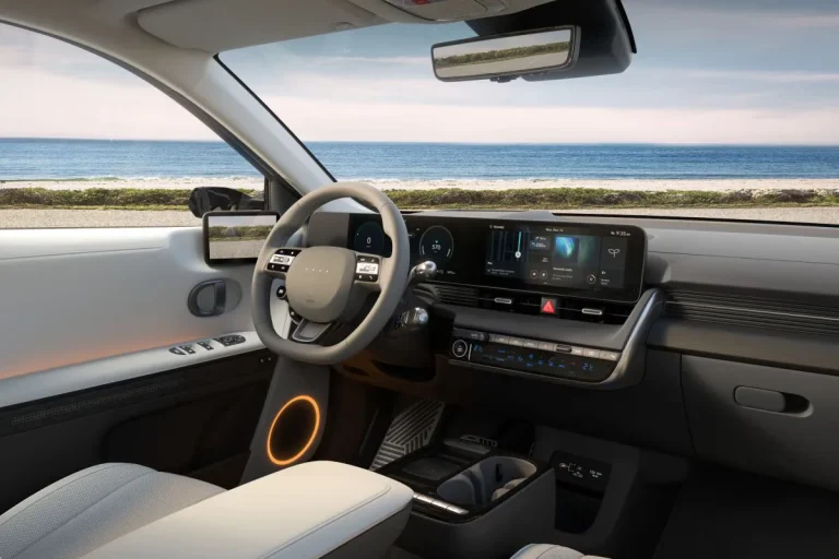 Hyundai IONIQ 5 leasen - portier en dashboard met oranje sfeerverlichting, zeezicht door het raam