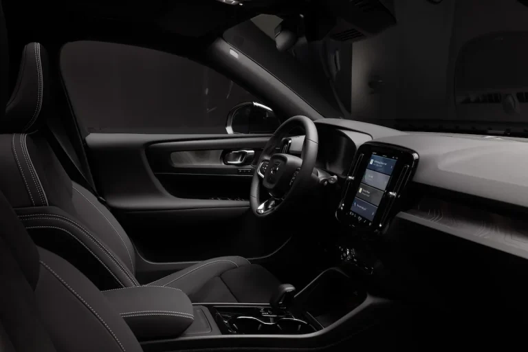 Volvo EX40 Black Edition leasen - dashboard en voorstoelen in zwart interieur, gezien vanaf de achterbank