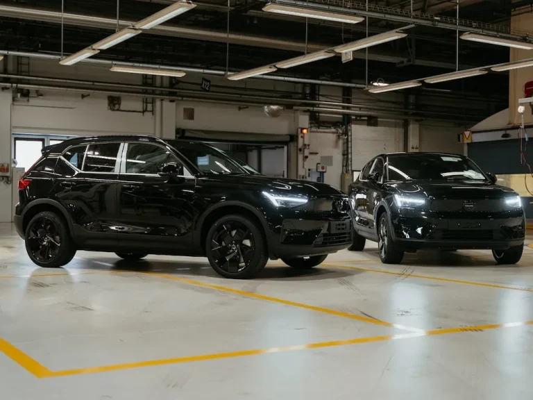 Volvo EX40 Black Edition leasen - twee zwarte uitvoeringen naast elkaar in een fabriekshal
