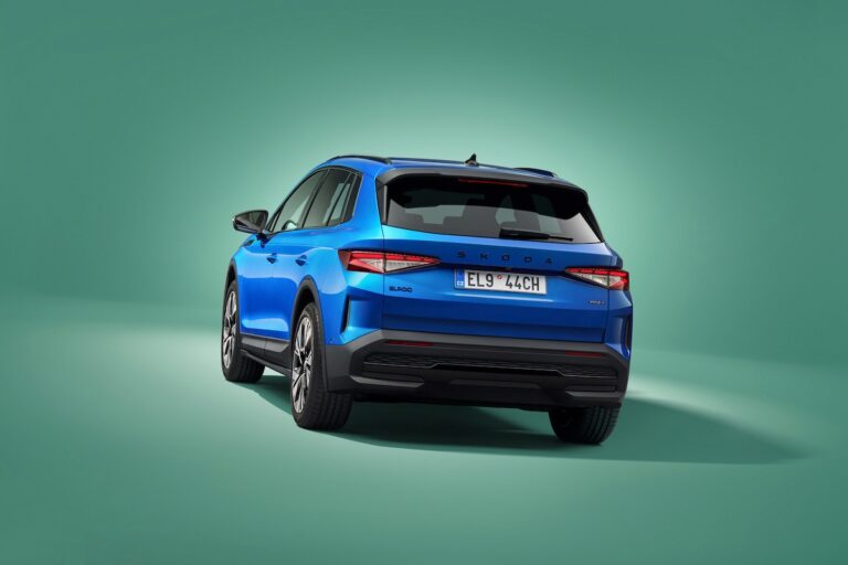 Skoda Elroq Sportline Leasen - schuin achteraanzicht op groene studio-achtergrond