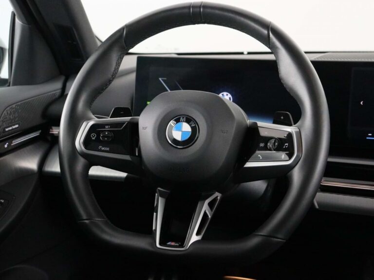 BMW 5-Serie Occasion Lease - close-up van het stuurwiel met BMW-logo en curved display