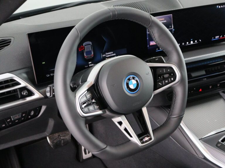 BMW i4 Occasion Lease - close-up van het stuurwiel met BMW-logo en gebogen schermen