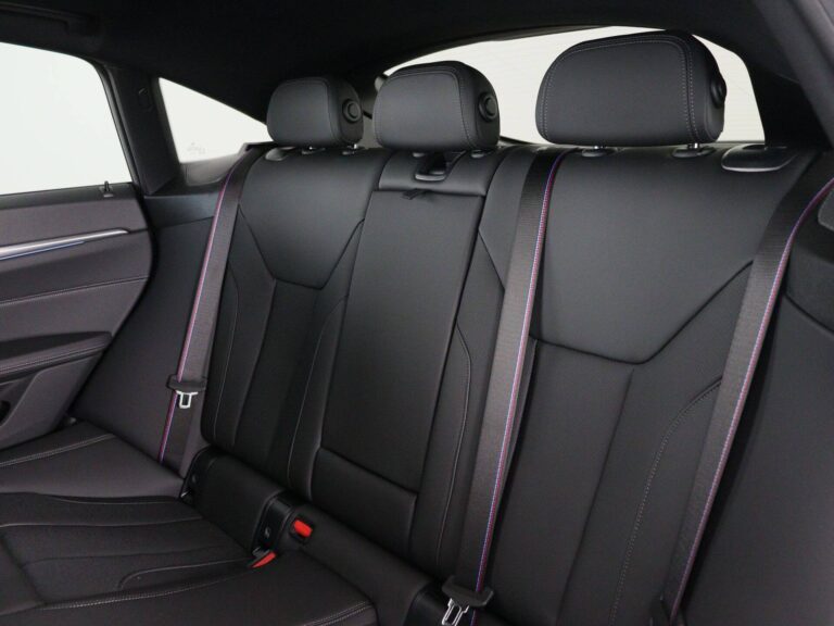 BMW i4 lease prijs - close-up van de achterbank in zwart leer met paars stiksel