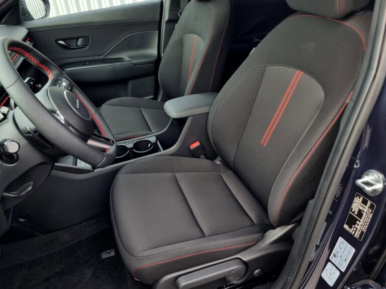 Hyundai Kona Occasion Lease - close-up van de voorstoelen met rood stiksel
