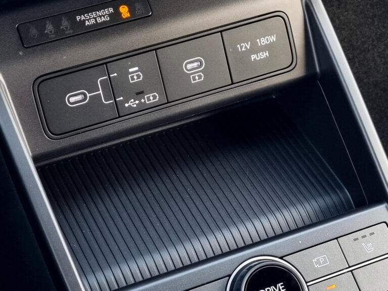 Leasing Hyundai Kona - close-up van de USB- en 12V-aansluitingen in de middenconsole