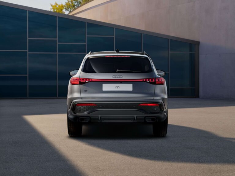 Audi q5 plug-in hybride zakelijk leasen - achteraanzicht van de grijze Q5 bij een modern gebouw
