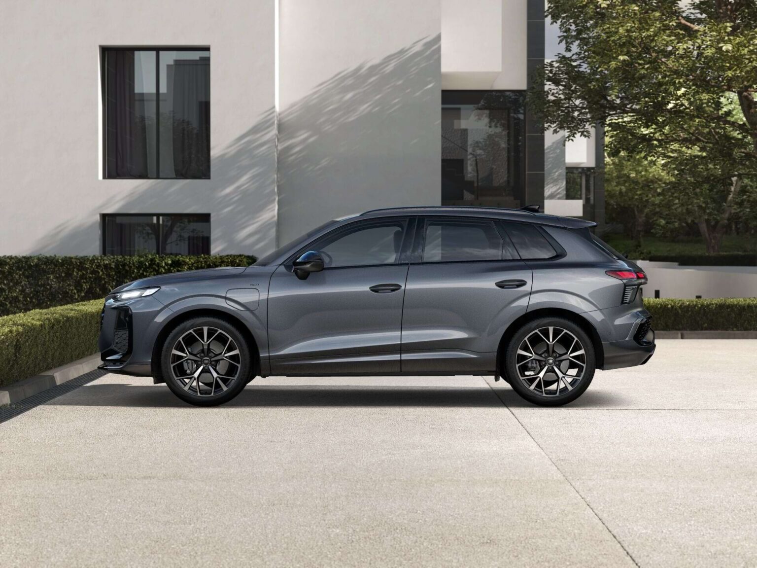 Audi Q3 zakelijk leasen - zijaanzicht van de grijze SUV bij een moderne villa