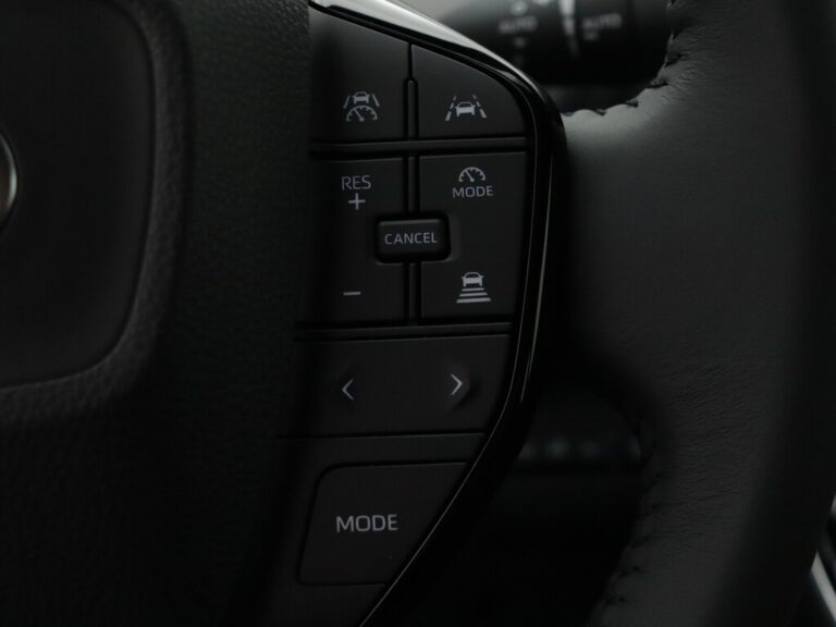 Toyota bZ4X leasen mkb - close-up van de linker stuurwielbediening voor cruisecontrol