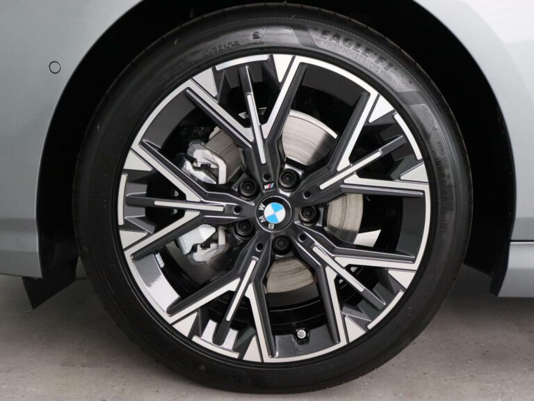 BMW 120 M Sport occasion lease - close-up van het voorwiel met remschijf en BMW-naafdop