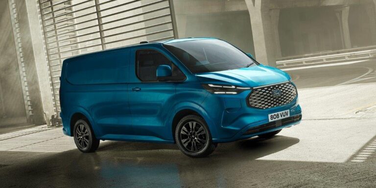 Ford Transit Custom full operational lease - schuin vooraanzicht van de turquoise bestelbus bij een industrieel pand