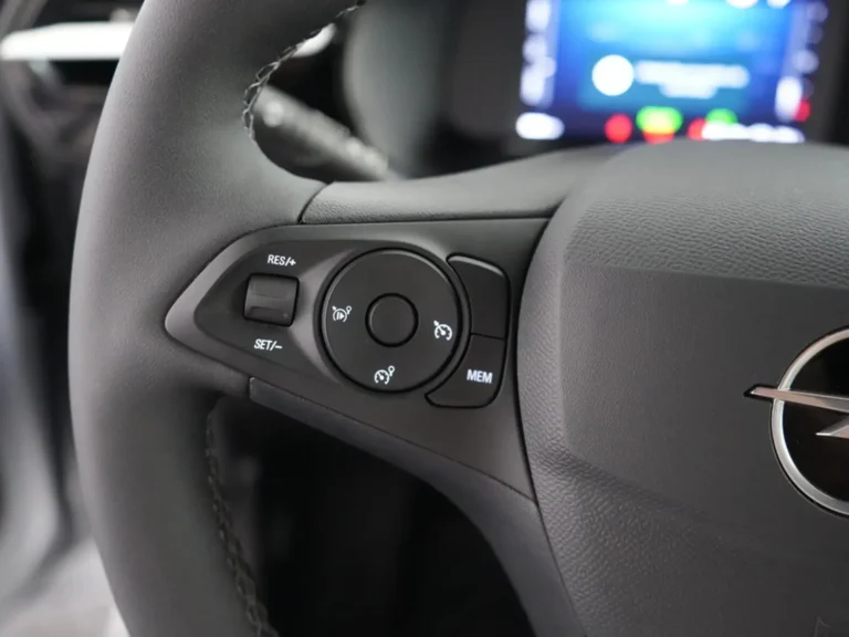 Opel Corsa-e zakelijk leasen uit voorraad - close-up van de linker stuurwielbediening voor cruisecontrol