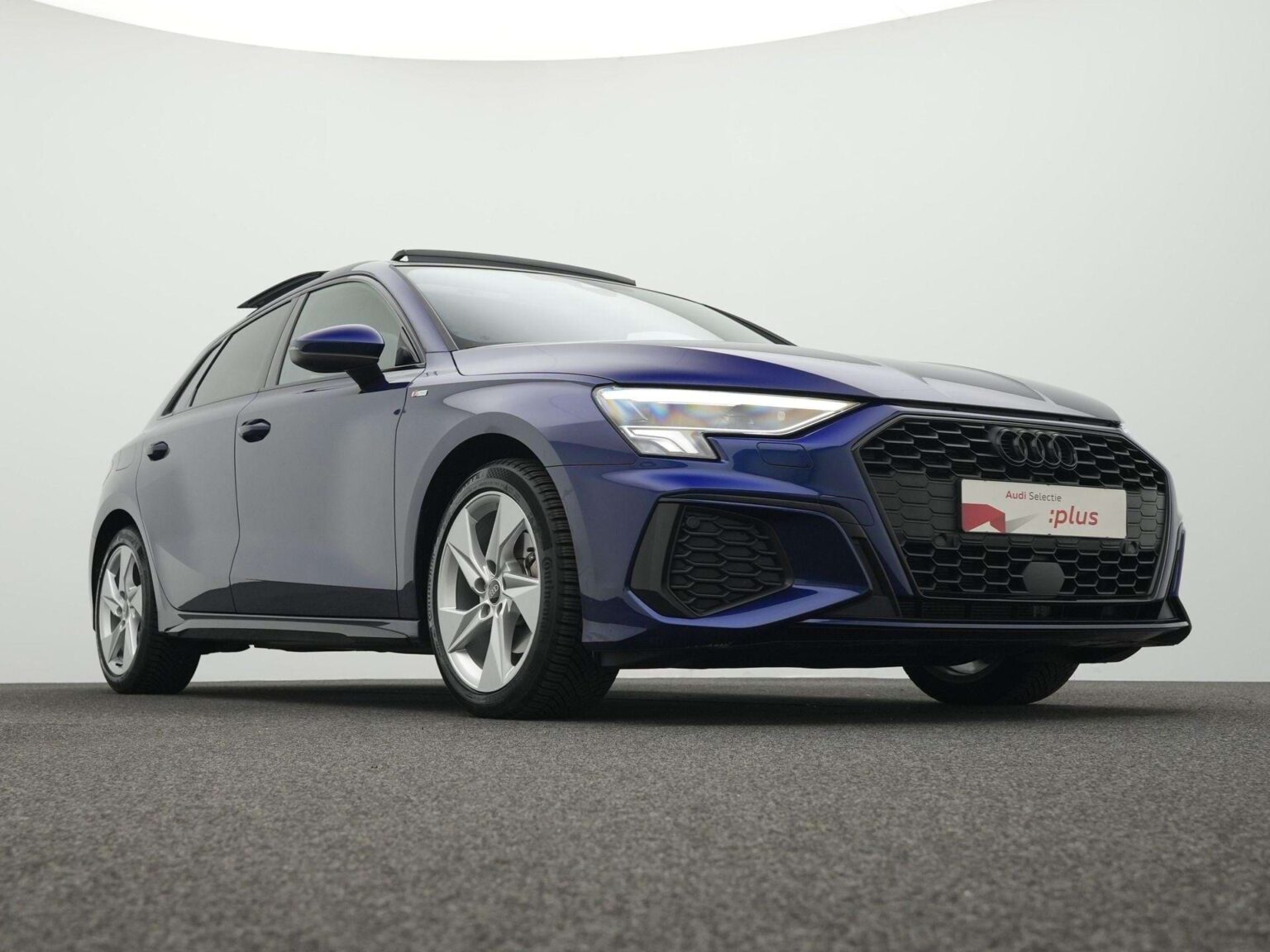 Audi A3 occasion lease met panoramadak - schuin vooraanzicht van de donkerblauwe Sportback