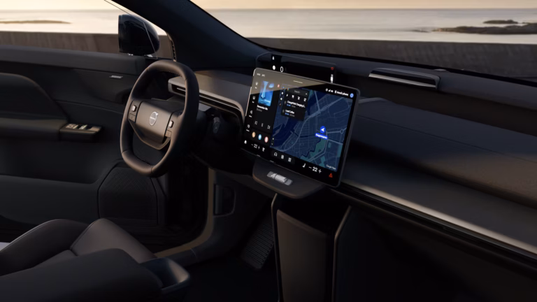 Full operational lease Volvo EX60 elektrisch - dashboard met stuurwiel en staand touchscreen, uitzicht op zee