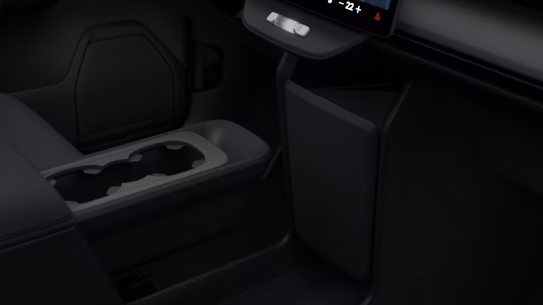 Volvo EX60 leaseprijs - close-up van de middenconsole met bekerhouders in het donker