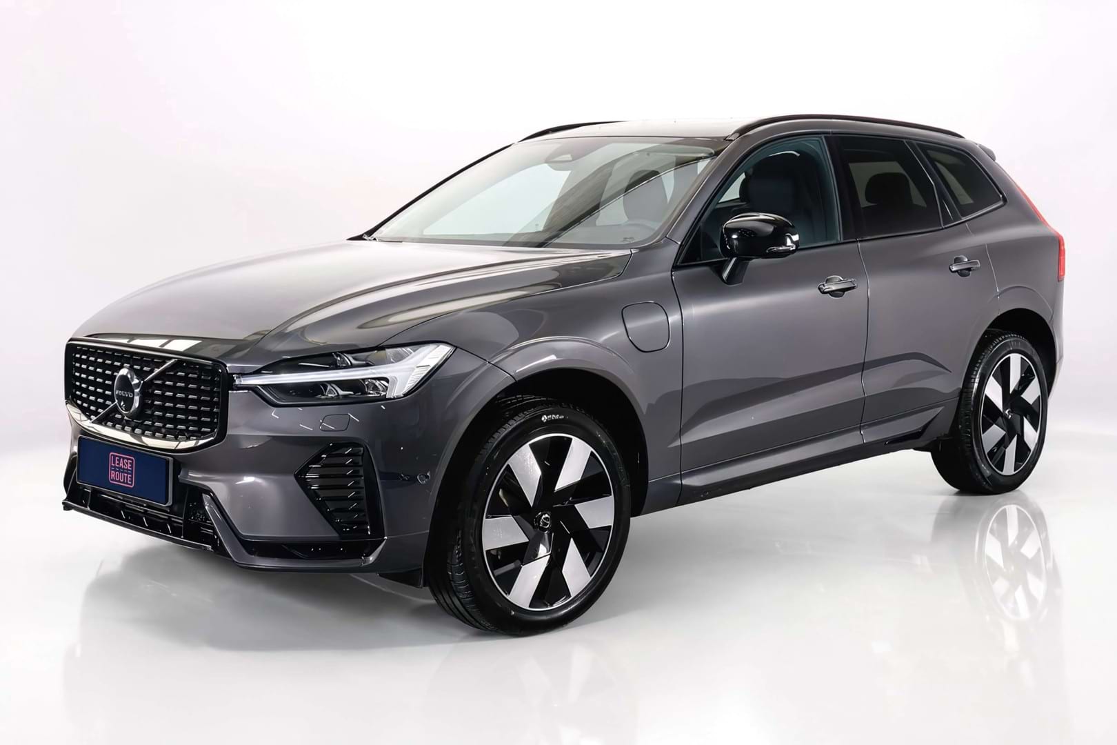 Gebruikte Volvo XC60 leasen met snelle levertijd - schuin vooraanzicht van de antracietkleurige plug-in hybride op witte studio-achtergrond
