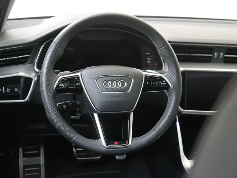 Audi A6 Avant jonge occasion lease - close-up van het quattro logo op het dashboard