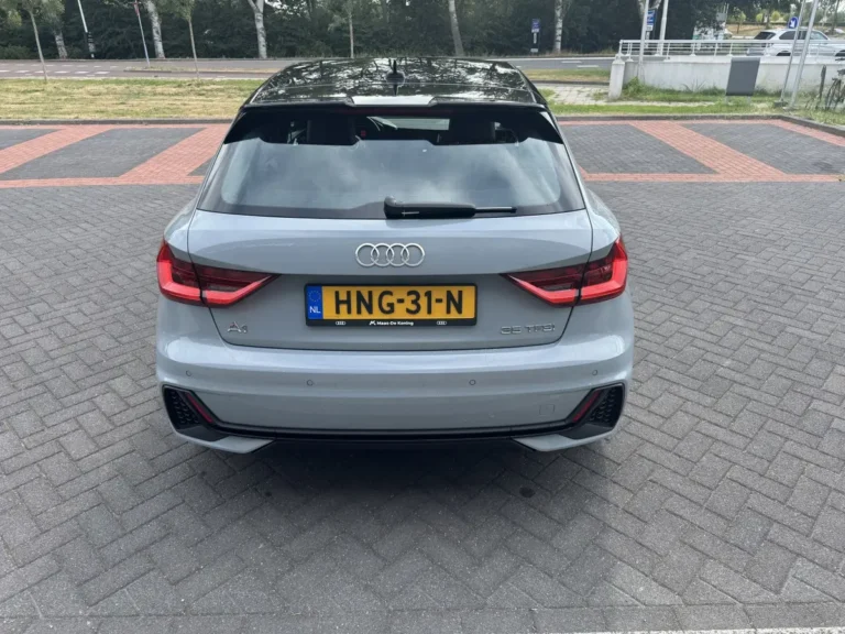Audi A1 Sportback, achteraanzicht op parkeerplaats met rode achterlichten en Nederlands kenteken