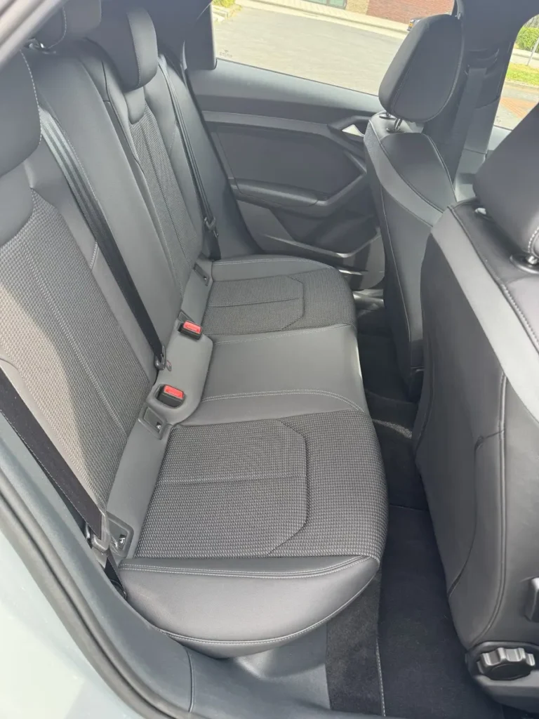 Audi A1 Sportback, interieur achterbank met grijze bekleding en rode veiligheidsgordels