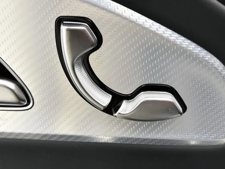 Mercedes-Benz CLA, detail deurklink aan zijkant met zwarte afwerking en geribde textuur