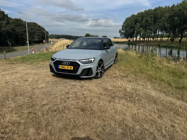 Audi A1 Sportback, schuin van voren links, geparkeerd in landelijk gebied met water en bomen