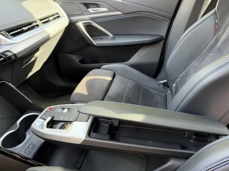 BMW iX1, middenconsole met bedieningspaneel, bekerhouders en armsteun