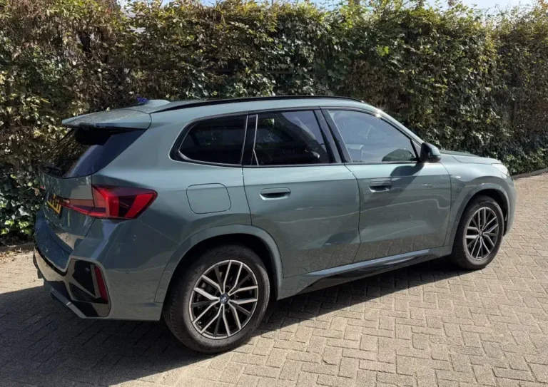 BMW iX1, schuin achteraanzicht rechts van de Cape York Green metallic SUV