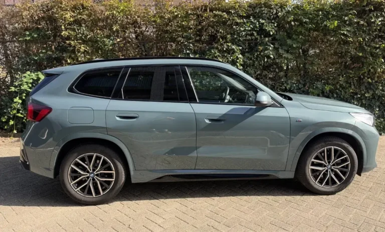 BMW iX1, rechterzijkant met 18-inch M lichtmetalen velgen in Bicolor Midnight Grey