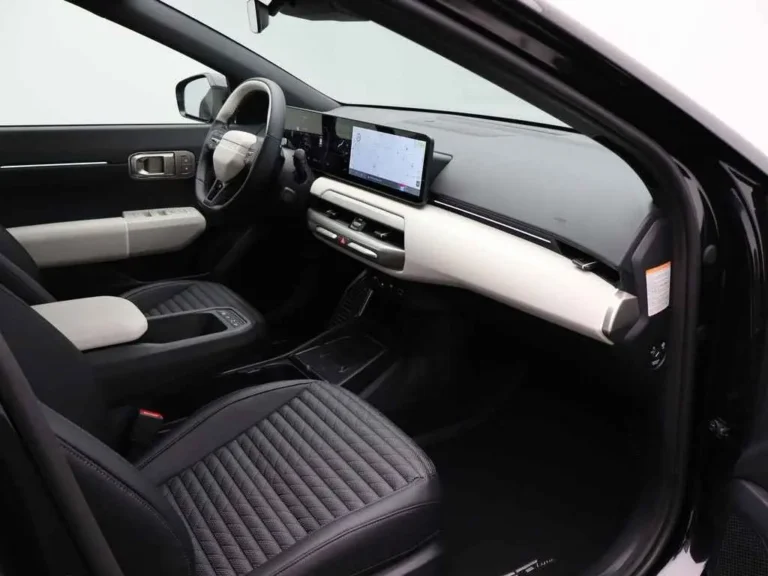 Kia EV4, dashboard en voorstoel aan de passagierszijde met middenarmsteun