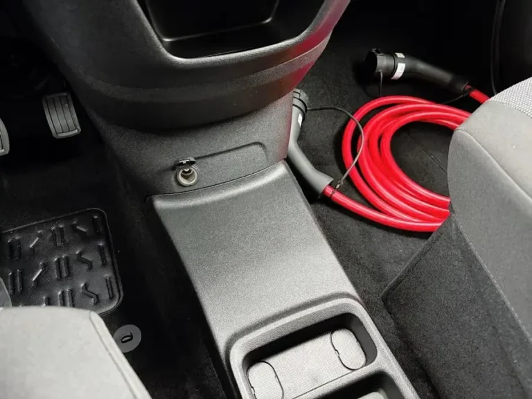 Opel Combo-e, rode laadkabel opgeborgen in de middenconsole tussen de stoelen